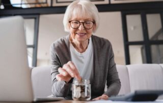 old lady depositing coins in a glass jar